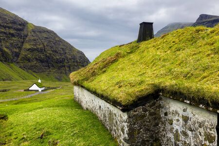 Saksun Village With Traditional Scandinavian Type Of Green Roof And Old Lutheran Church and Cemeteryの写真素材