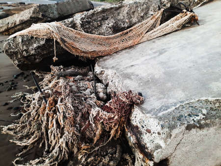 Remains of old fishing nets on the ruins of buildings by the sea
