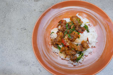 Most favorite and popular street food or homemade food of Thailand, Crispy pork belly with stir fried basil top on rice. It has a spicy, salty, sweet taste. Itâs call in Thai Kapao moo krob. Asian food, shot from above view.の写真素材