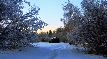 winter sunset landscape with wooden shelterの写真素材