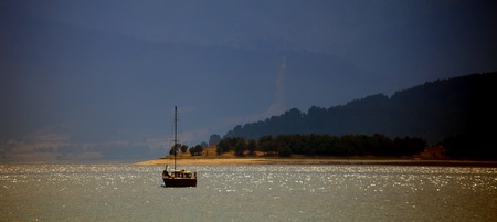 bulgarian batak dam lake sunset with fishing boatの写真素材