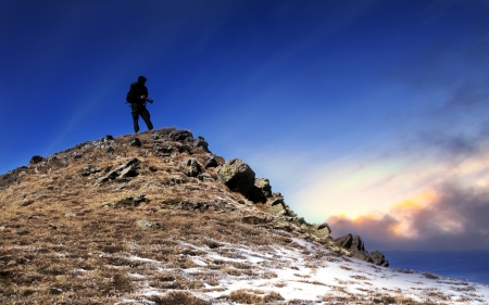 HDR sunset in high mountain with photographer on top of the hillの写真素材