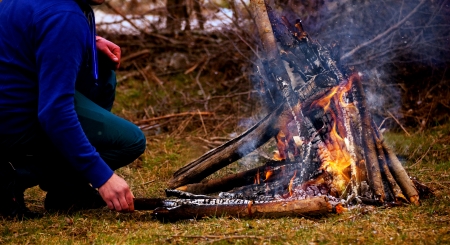 man stay near camp fire 