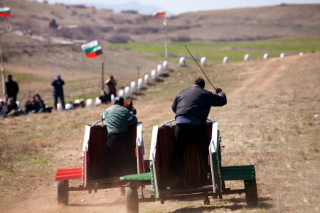 NOVO SELO, BULGARIA- MARCH 23: two gypsy man riding chariot  in horse games  held each year on March 23 , 2013 in Novo Selo, Bulgariaのeditorial素材