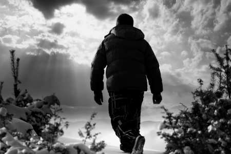 landscape in black and white with man walking in snow mountains 