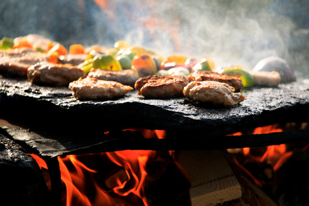 hand-made bbq in forest with beacon and vegetable on stone plate の写真素材