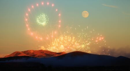 beautiful fireworks in sunset time with ricing moon on horizonの写真素材