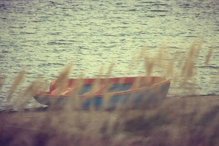 Vintage photo of old boat for fishing on the lakeNature background, vintage effect and INK modern filterの写真素材