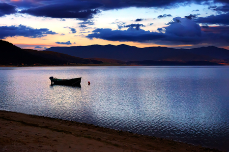 calm HDR sunset over the high mountain bulgarian lake, boat in foregroundの写真素材