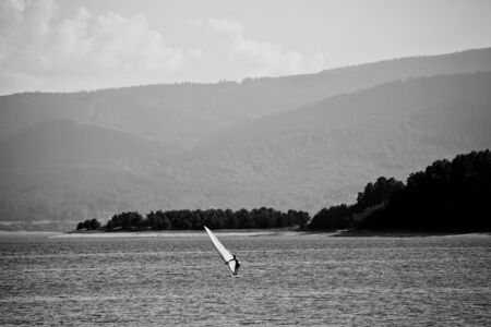 black and white landscape with windsurffer in high mountain bulgarian lakeの写真素材