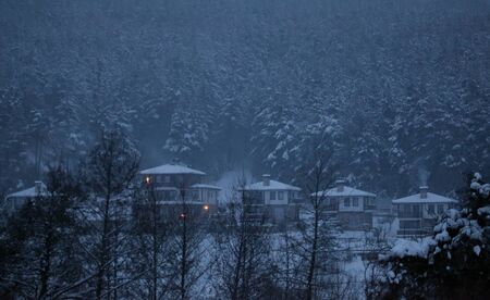 dramatik snow winter night landscape over the small houses in bulgarian mountains の写真素材
