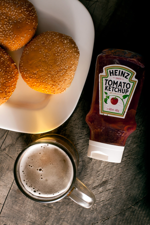 DORKOVO, BULGARIA - FEBRUARY 08, 2017: Vertical close up shot on a single bottle of Heinz Tom and burgers with bear over wooden background. Heinz started manufacturing food products in the USA in 1869のeditorial素材