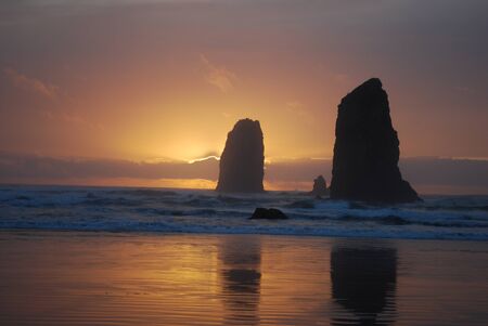 sunset behind coastal rock formationsの写真素材
