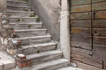 decaying stairway and door of abandoned mediterranean houseの写真素材