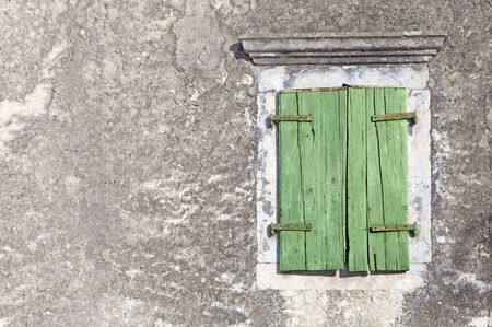 wooden green window on aged plastered wallの写真素材