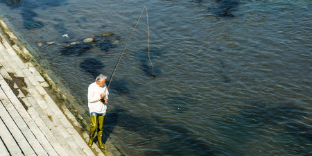 Adult man fishing in the river Vardar in Skopje 