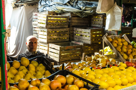 Adult man selling pears,apples and lemons in the old bazaar in Skopje のeditorial素材