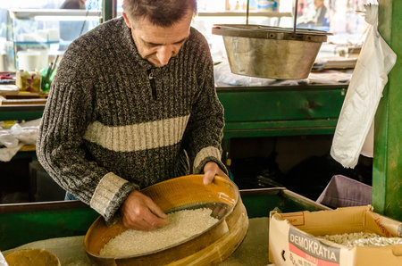 Adoult man cleaning the rice for sale in the Old Bazaar in Skopje のeditorial素材