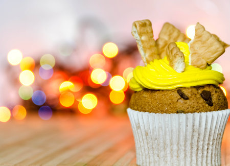 Yellow cream cupcake with bisquits on top of it 