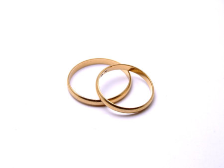 golden wedding rings on white backgroundの写真素材