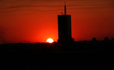 sun setting over big cityの写真素材