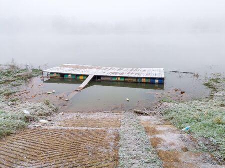 Water platform and driveway for vehicles on the river. A thick autumn fog by the water.の写真素材