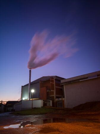 Combustion of fossil fuels releases sulfur dioxide goes into the atmosphere where it mixes with water and returns in the form of acid rain. Human impact on nature and causing environmental disasters.の写真素材