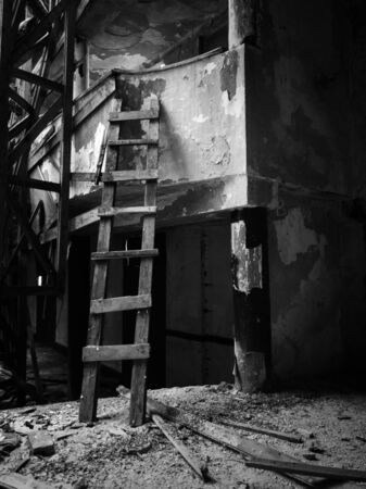 A wooden ladder leaning against the balcony in an abandoned dilapidated theater building.の写真素材