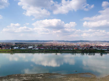 Scenic view of Sava river and settlements around Slavonski Brod during sunny day with fluffy clouds.の写真素材
