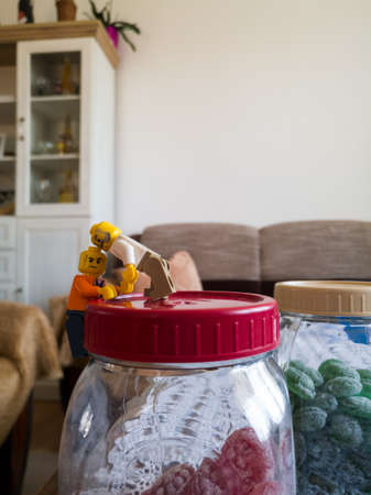 Lego toys in the living room, climbing on the lid of a candy jar, A story told with fun with...
