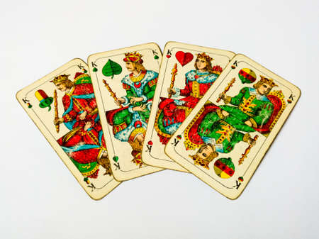 Four old king cards from deck of playing cards with german suits - acorn, leaf, heart and bell, isolated on white background.のeditorial素材