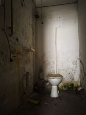 Detail from messy interior of abandoned building. Restroom with mold and moisture on a wall with a humidity dirty and unhealthy environment and dirty toilet.の写真素材