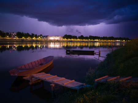 Storm overcast with thunderclouds and the glow of lightning. Landscape with city of Slavonski Brod...