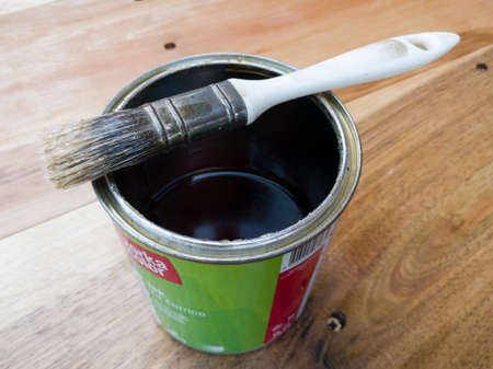 Brush on top of open varnish can on wooden plank, concept of decoration and modernization, home design and renovation, wood paintworkのeditorial素材