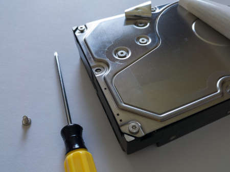 Repair broken computer part for data storage, unscrewed screw and screwdriver, hard disc drive (hdd)...