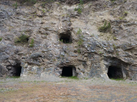 Abandoned industrial mines entrance, dark spooky asbestos shaft in rock, dangerous urban exploration, asbestos cancersの写真素材