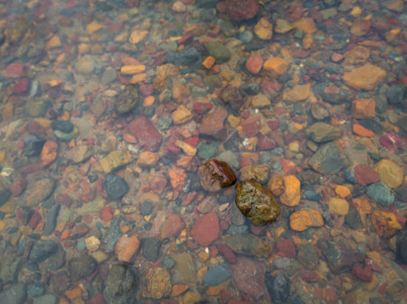 Two wet stones in shallow water and colorful underwater stones, abstract landscapeの写真素材