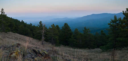 View of the slopes of the mountain Ozren from the peak Gostilj, a landscape of hilly Balkans with haze on the horizon at duskの写真素材