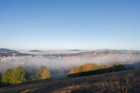 View of the tourist town of Zlatibor in the fog on the mountain Zlatibor in Serbia surrounded by...