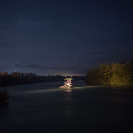 A house on a rock in the middle of the river Drina near the town of Bajina Basta at night, Serbiaの写真素材