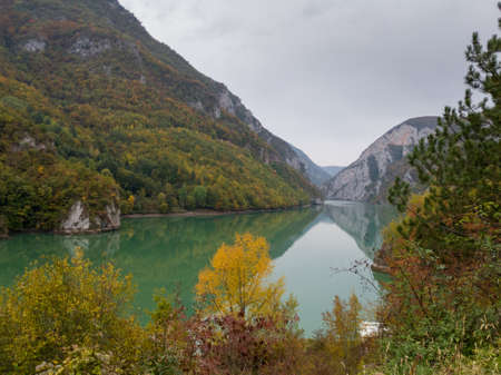 The canyon of the river Drina in autumn colors on the vegetation during a cloudy dayの写真素材