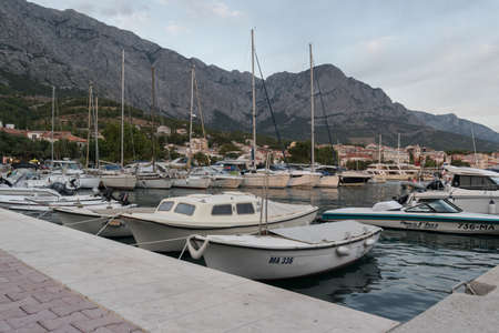 Moored boats in Adriatic sea in marina in touristic resort Baska Voda, Croatia