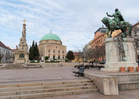 Hunyadi Statue, Holy Trinity Statue and Mosque of Pasha Qasim on Szechenyi square in city of Pecs Hungary Europeのeditorial素材