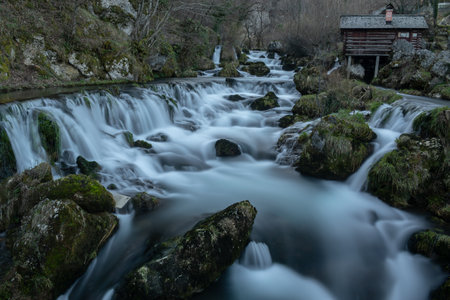 Mountain river with mossy rocks and wooden watermills in long exposure, river Krupa in Krupa na Vrbasuの写真素材