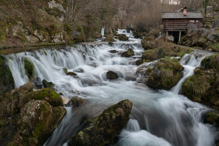 Mountain river with mossy rocks and wooden watermills in long exposure, river Krupa in Krupa na Vrbasuの写真素材