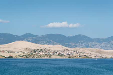 Pag island with coastal settlement and mountain Velebit in hazeの写真素材