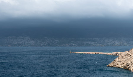 Landscape with wavy sea and dark stormy clouds above mountain Velebit in Dalmatia, dangerous weatherの写真素材