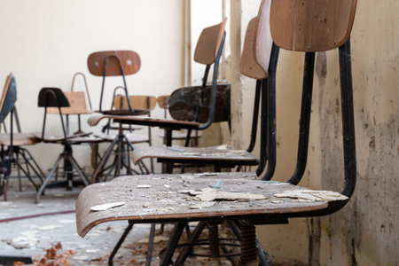 Dirty chairs in abandoned room made of wood with metal frame, urban explorationの写真素材