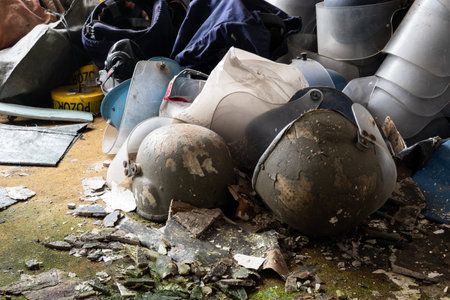 Deserted demining helmets on messy floor in abandoned room, protective equipment