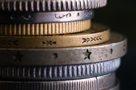 Edges of various coins stacked in pile close up, reeded and decorated, uncirculated metal money with scratches and corrosion damageの写真素材